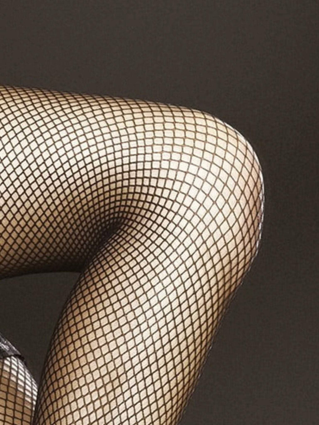 Bein in schwarzen Netzstrümpfen, klassische Nylonstrümpfe für Damen, elegant