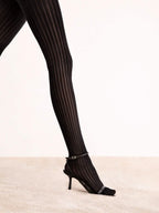 Schwarze Strumpfhose mit Streifenmuster und High Heels auf hellem Teppich