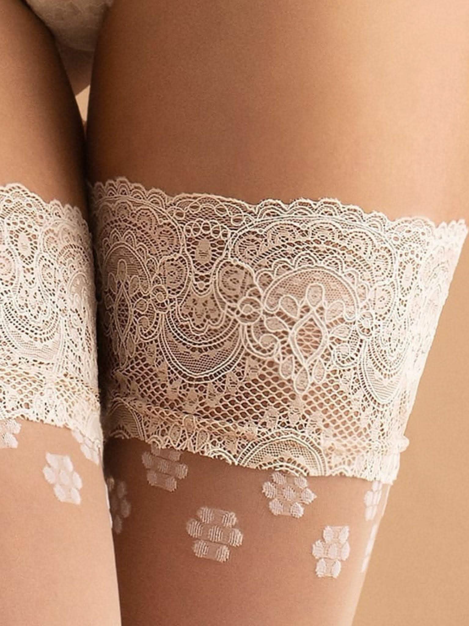 Weiße halterlose Braut-Strümpfe mit Spitzenabschluss und floralem Muster am Oberschenkel