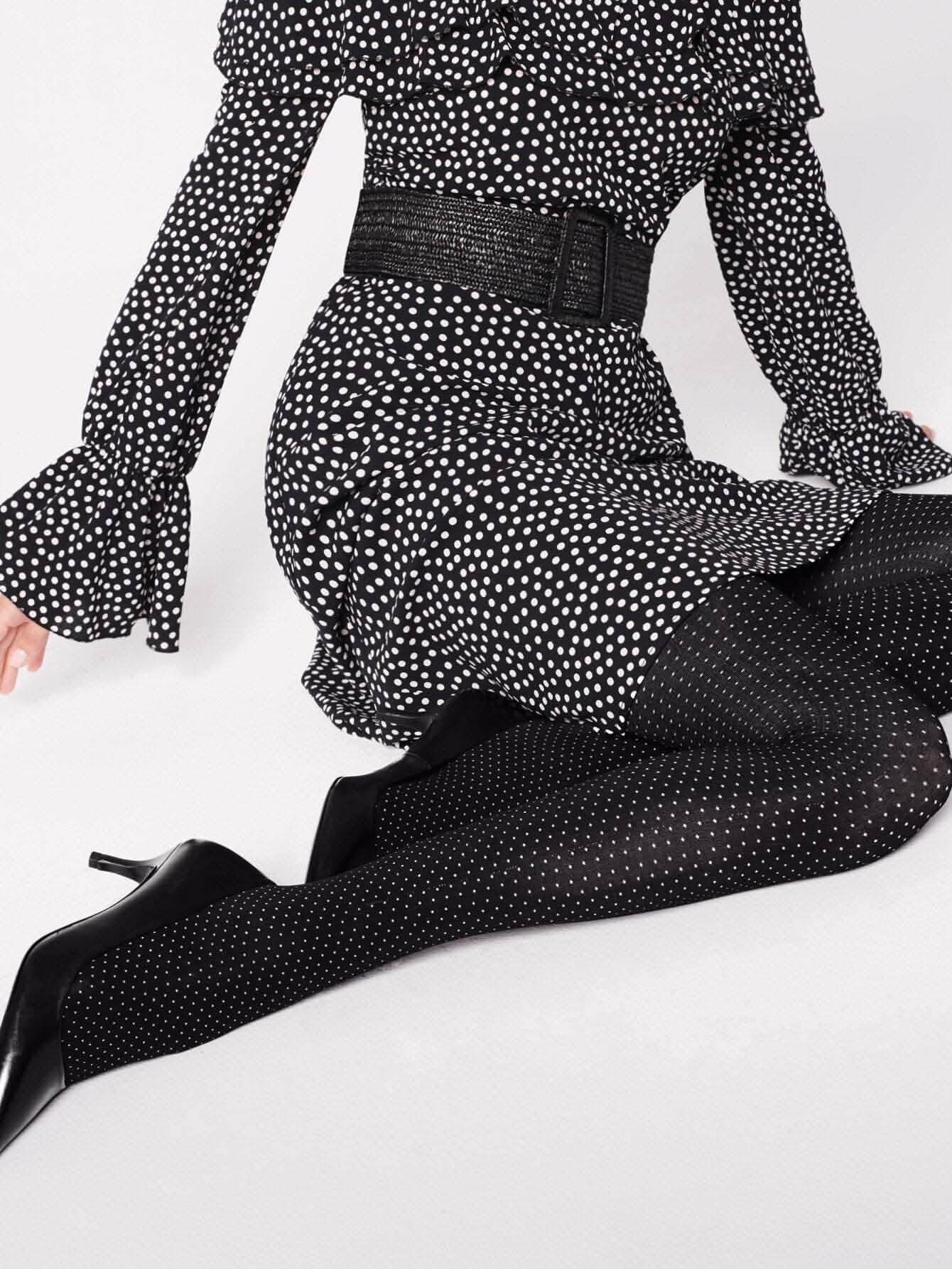 Frau in gepunktetem Kleid und gepunkteter Strumpfhose, elegante schwarze High Heels Hovedbillede